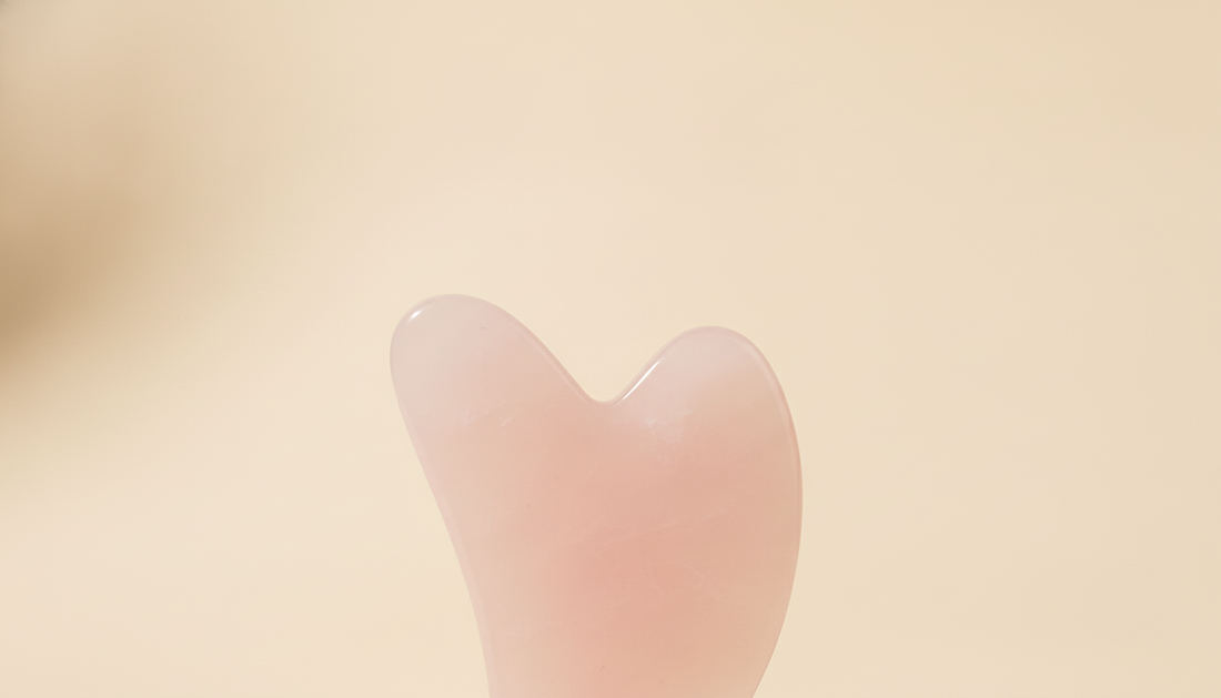 Primo piano su un gua sha in quarzo rosa naturale, venature e texture della pietra vera